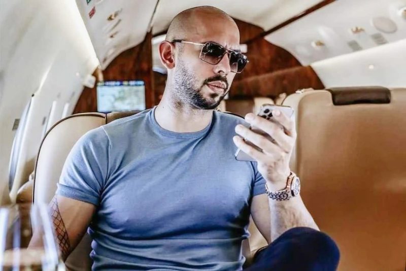 Andrew Tate watching his phone in a private jet
